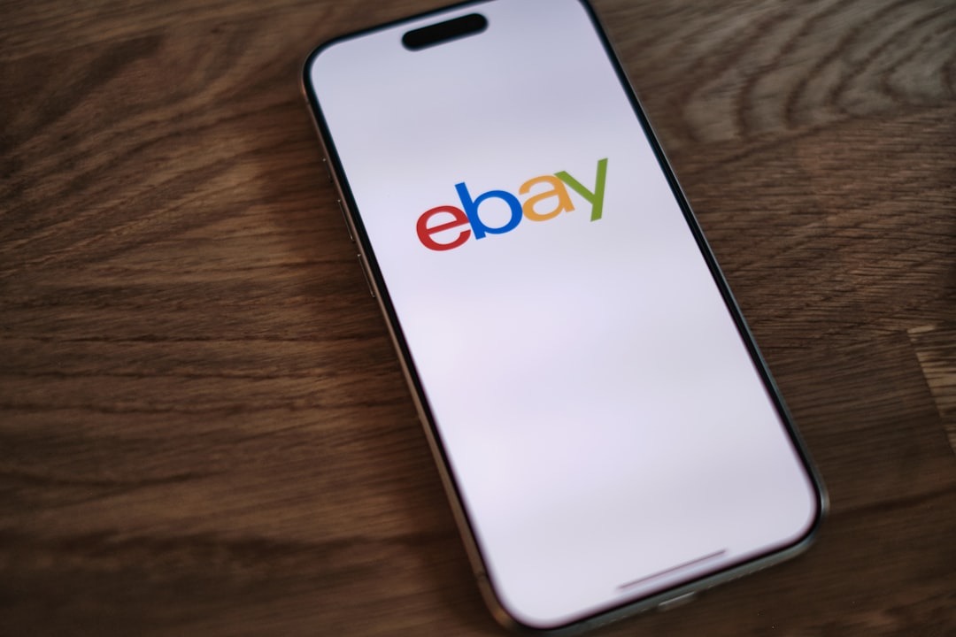 Smartphone displaying the colorful eBay logo on a wooden surface.